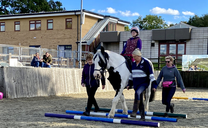 Poppy riding Paddy over poles.